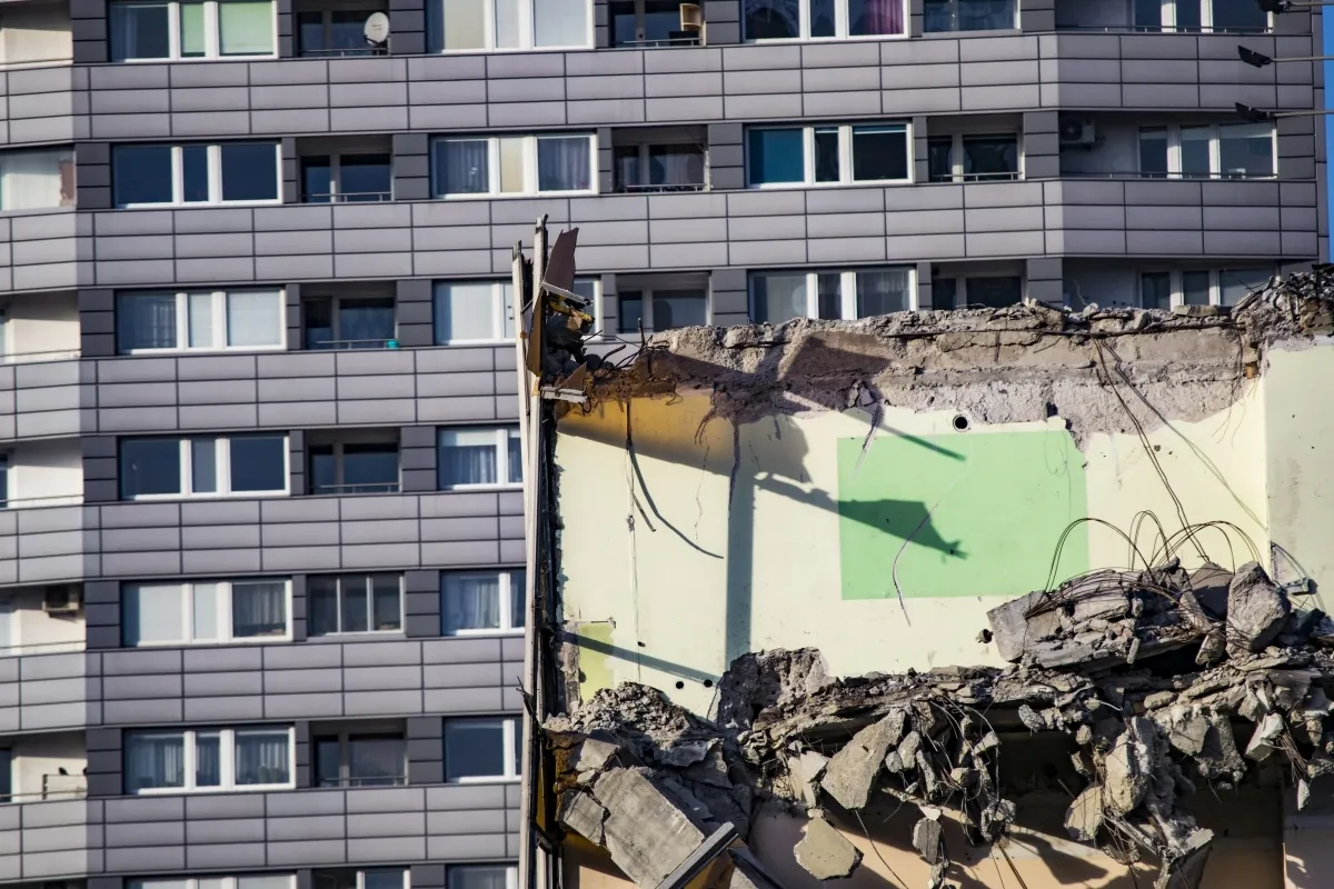 Crumbling mural wall beside rows of apartment balconies